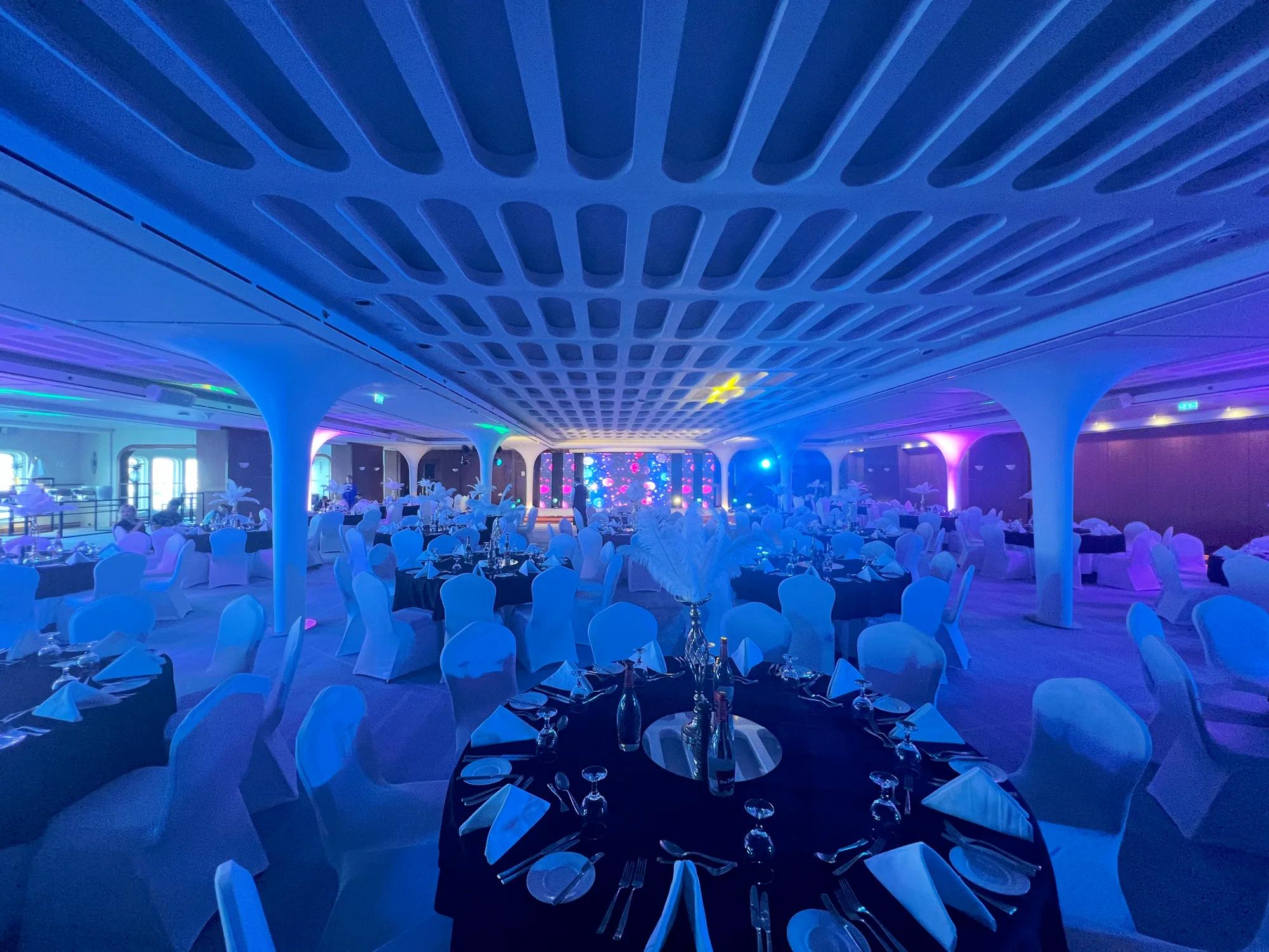 Representative banquet hall prepared with tables, stage lighting and a presentation screen