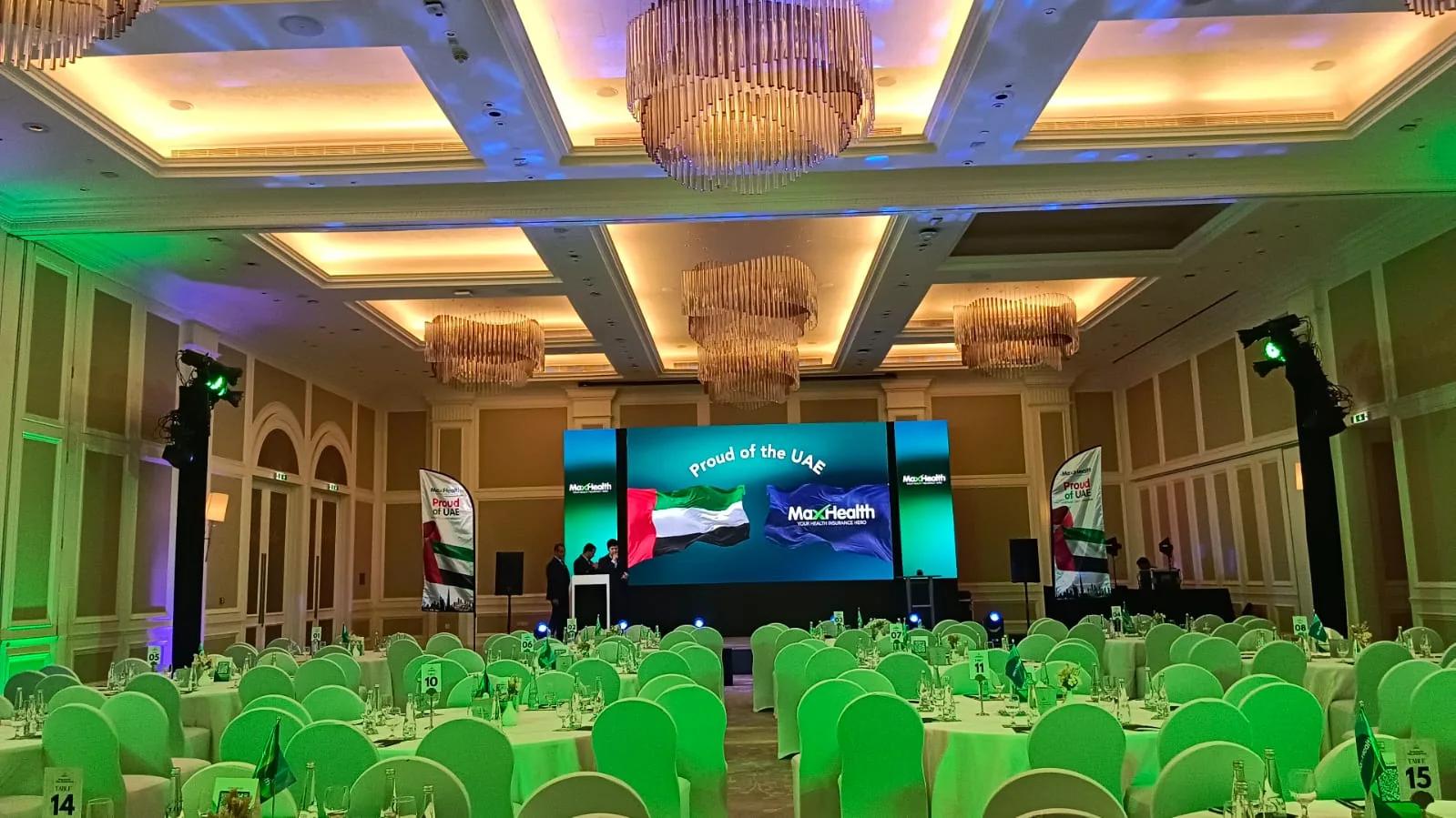 Corporate conference room with a wide LED stage and banquet seating.