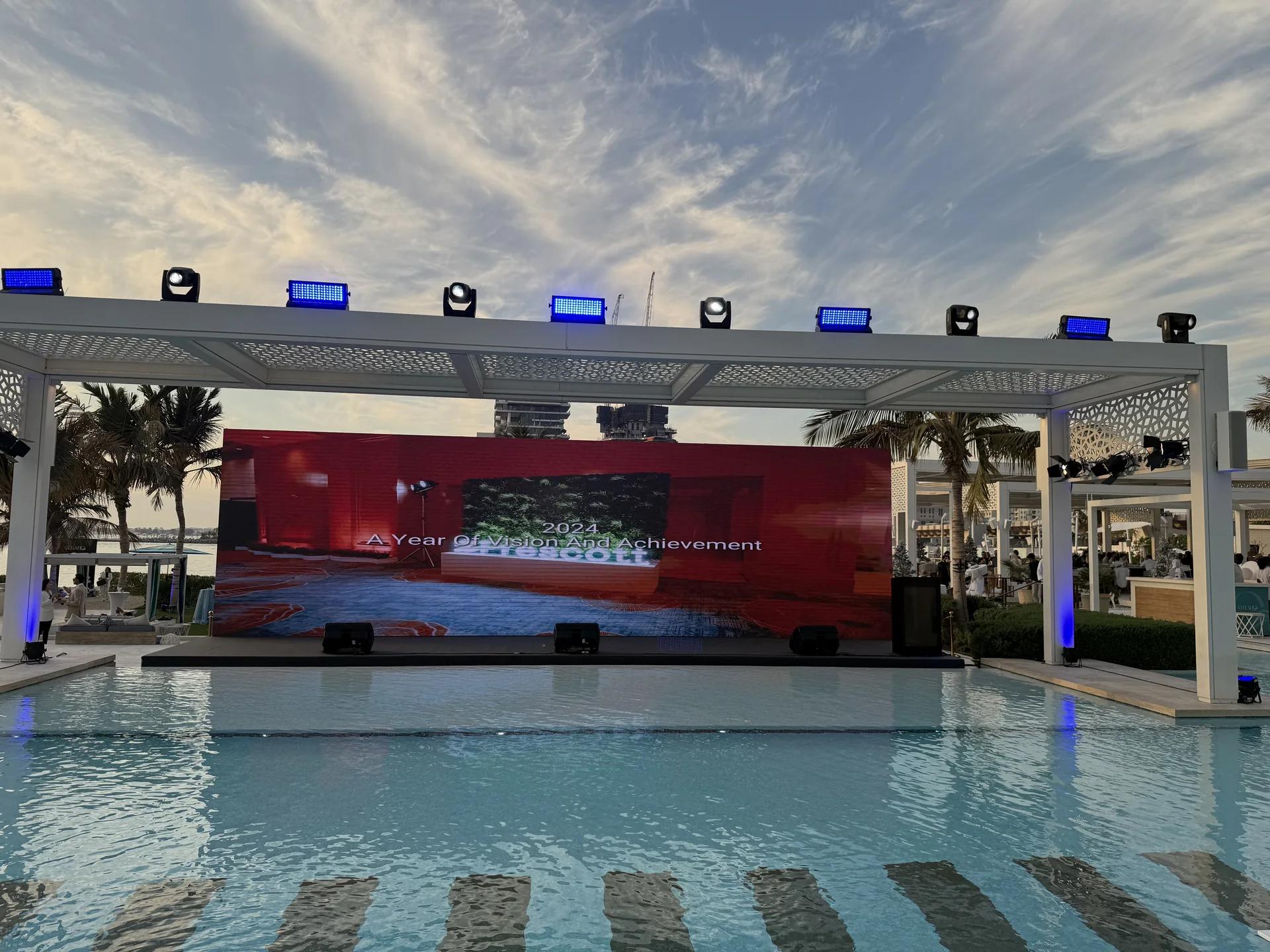 Outdoor destination stage built beside a resort pool.