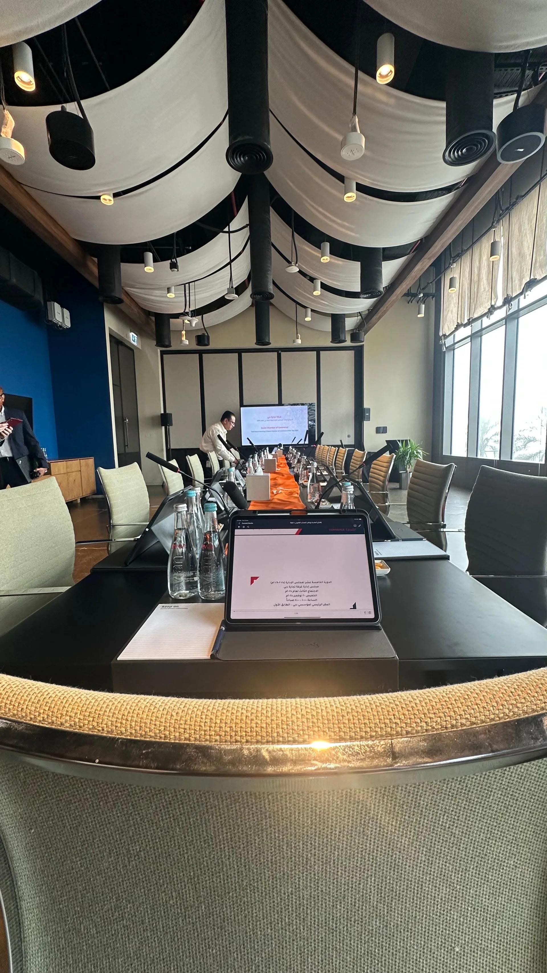 Boardroom meeting layout with microphones, delegate tablets and presentation display.
