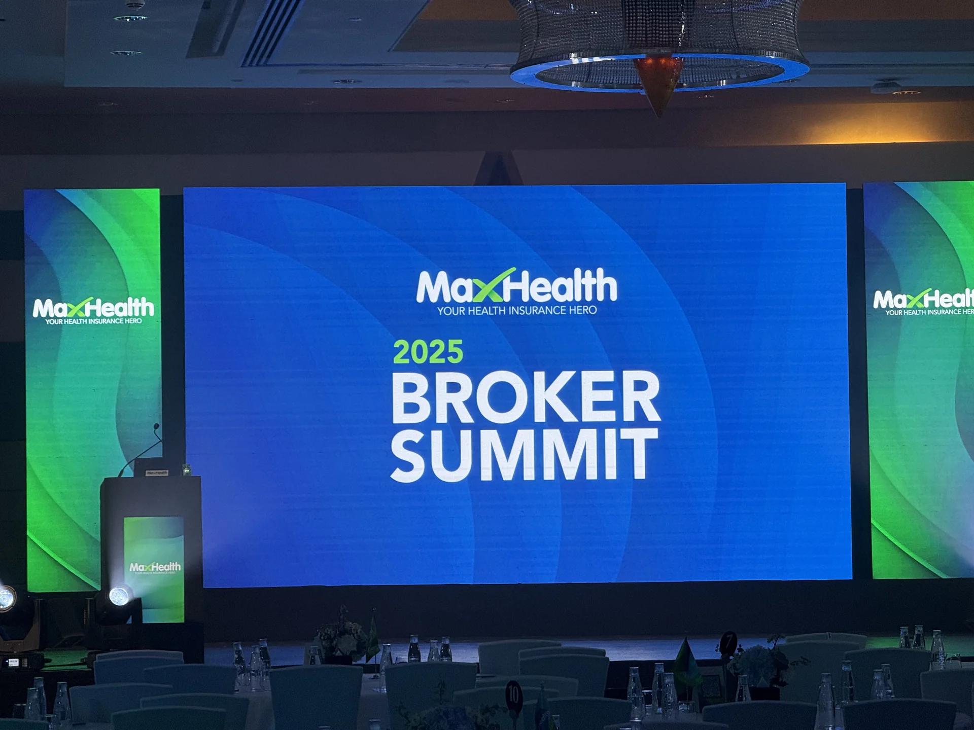 Corporate summit stage with a large LED screen and lectern.