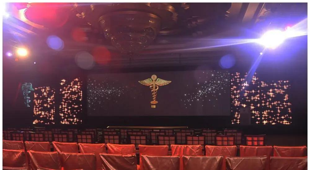 Gala stage with a star-field LED backdrop and audience seating.