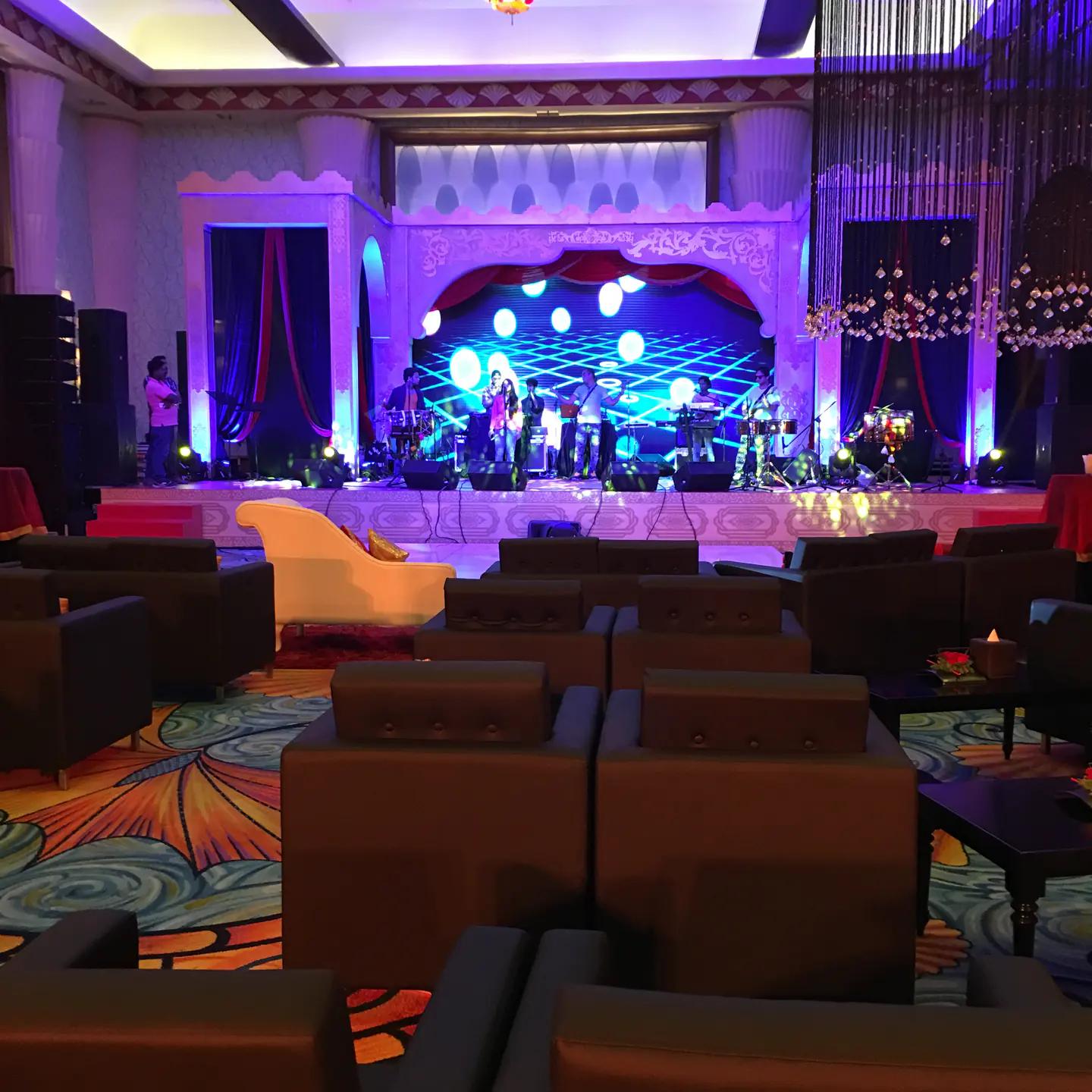 Live band stage framed by blue lighting in a private celebration ballroom.