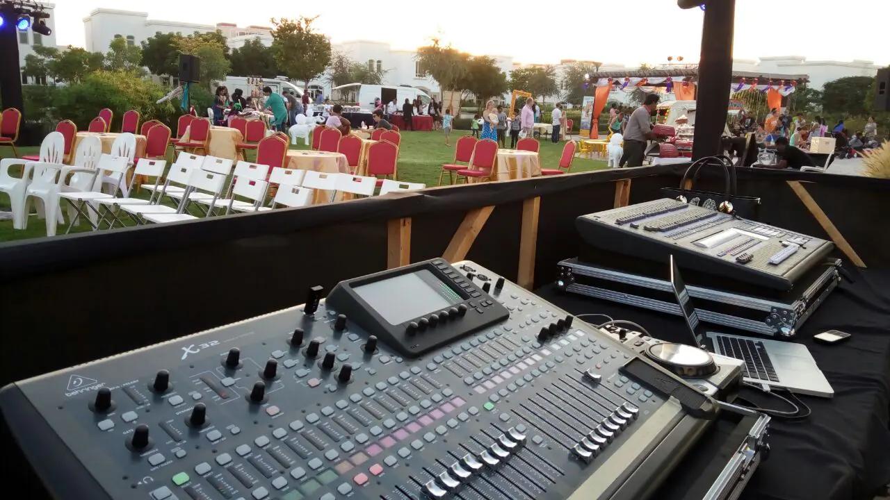 Audio mixing console overlooking an outdoor audience area.