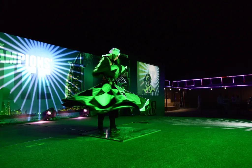 Night performance with illuminated spinning costumes on an outdoor stage.