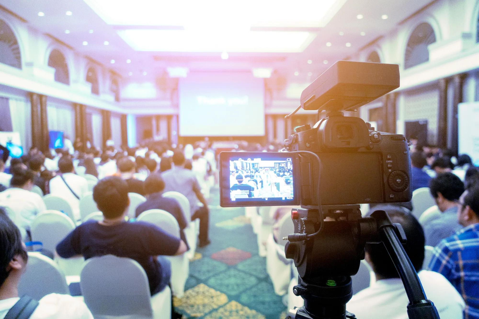 Conference hall prepared for guests and a live production camera