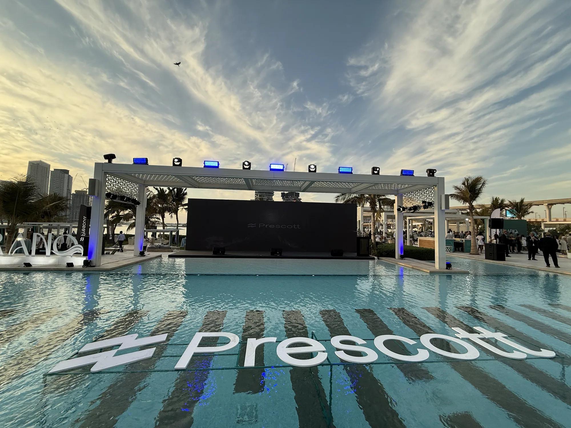 Outdoor stage structure beside a resort pool at sunset
