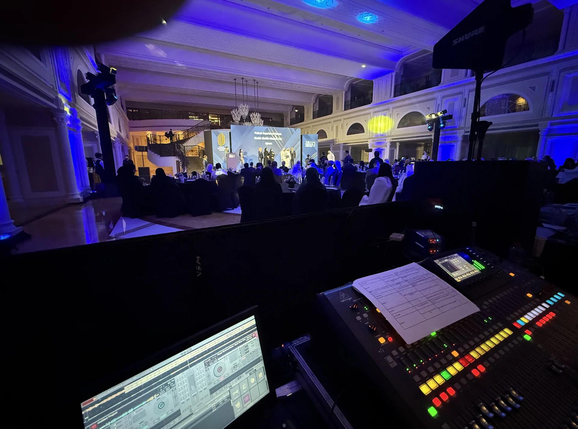 Front-of-house production desk overlooking a live conference environment