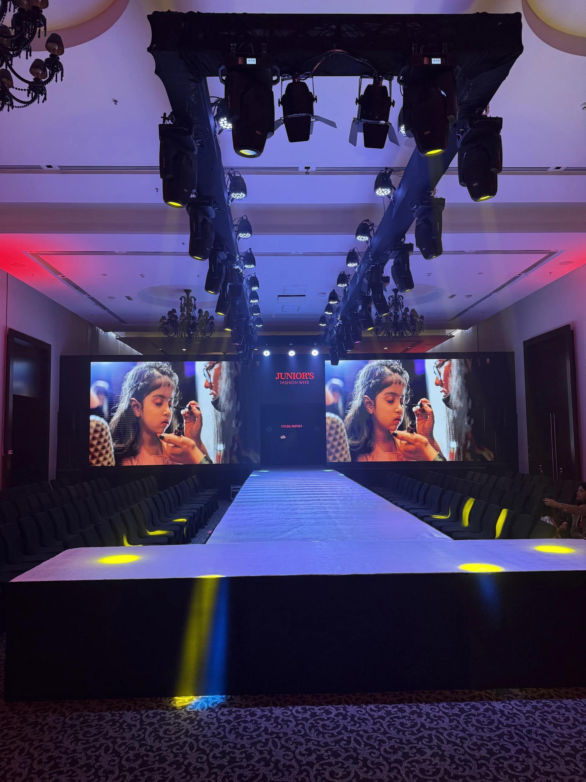 Runway environment with a wide LED backdrop, lighting truss and audience seating.